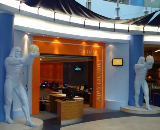 Orange entrance to the Bargate Internet Café, with one monumental white male figure holding a globe on each side.